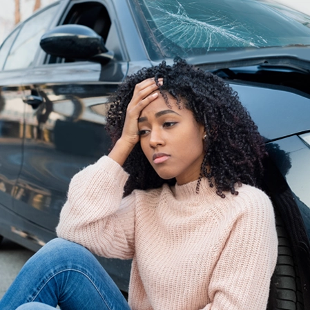 Woman holding head after car accident